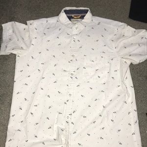 White button down shirt with paper airplanes On it